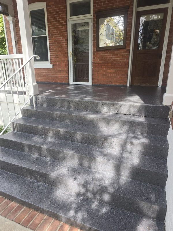 Porch and steps with a dark decorative coated finish and white railing