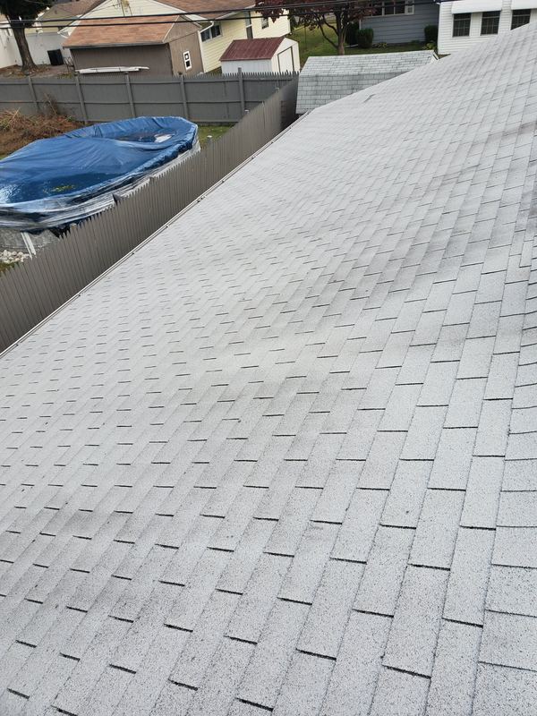 Freshly installed light gray shingle roof along the eave